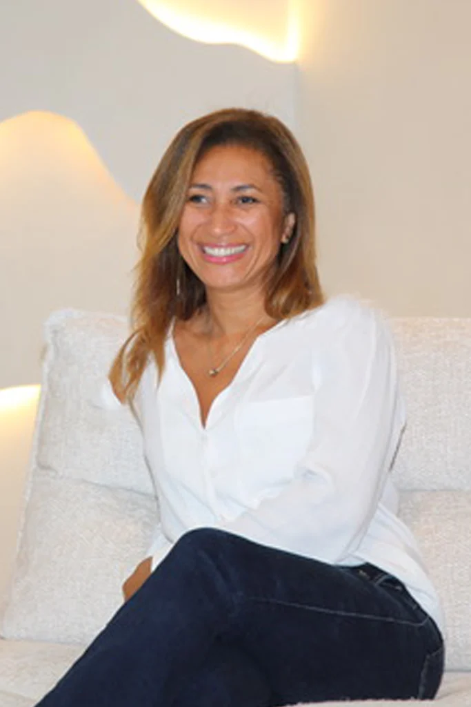 Laure Mora Femme souriante portant une blouse blanche, regardant l’objectif
