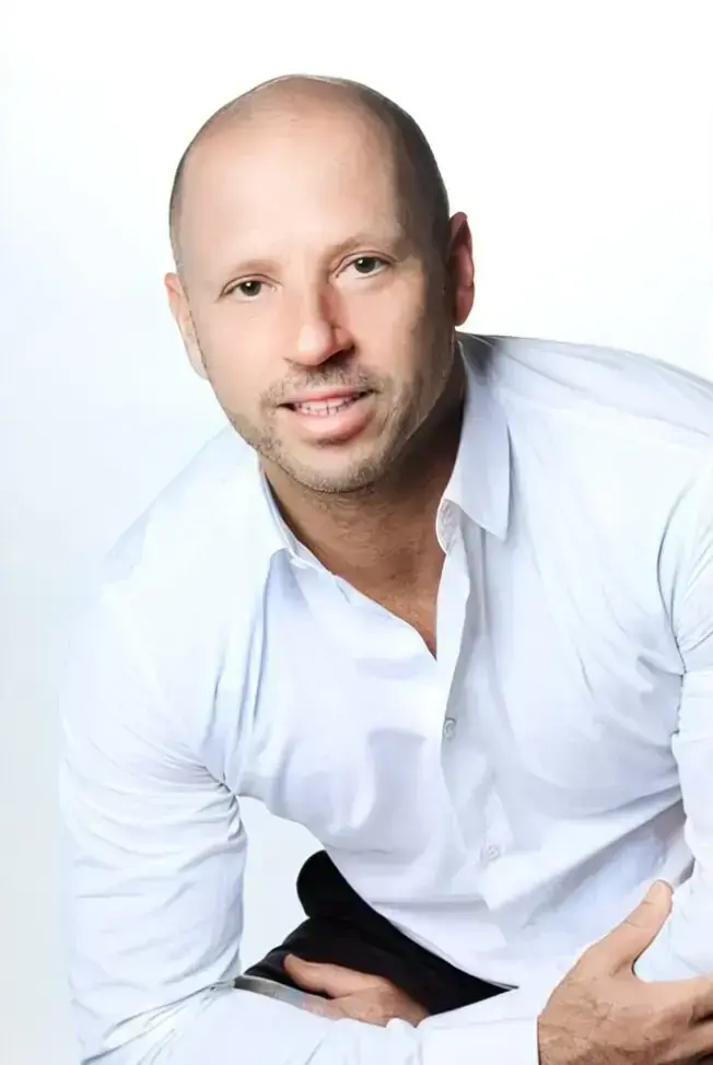 Philippe Boccara souriant portant une chemise blanche, photographié de trois quarts