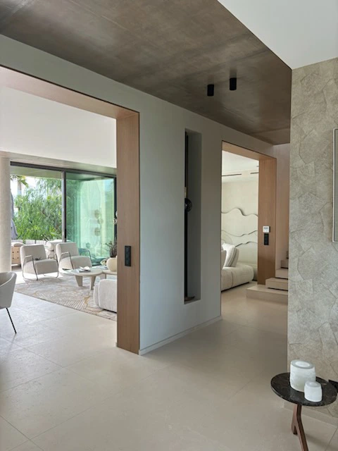Salon lumineux avec grandes ouvertures sur l’extérieur.