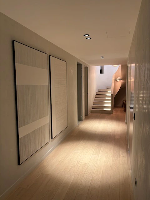 Couloir lumineux avec décor mural minimaliste.