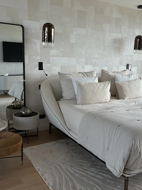 Chambre moderne avec lit design et suspension en verre.