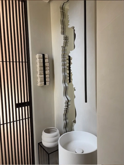 Salle de bain avec miroir original et vasque design.